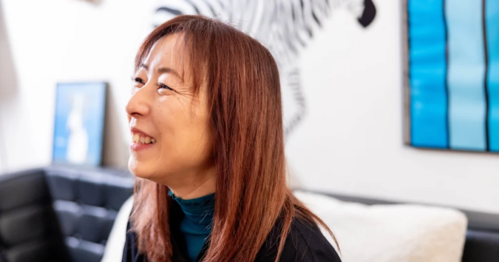 笑顔で糸掛け曼荼羅について語る女性講師平尾さんの横顔