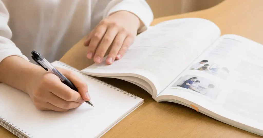 介護記録をノートに記入している手元の様子