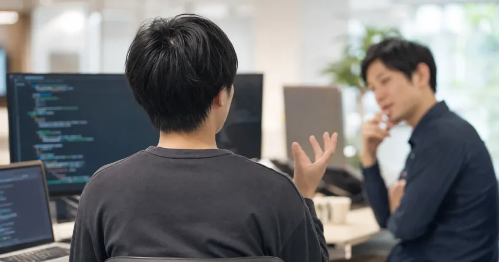 QAエンジニアがチームでレビューや相談を行っている様子
